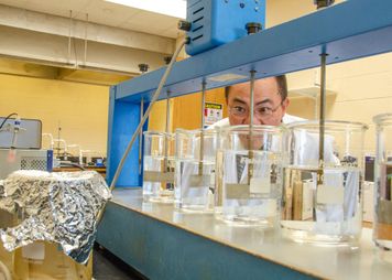 Lian Shin Lin looking at liquid in glass cylinders